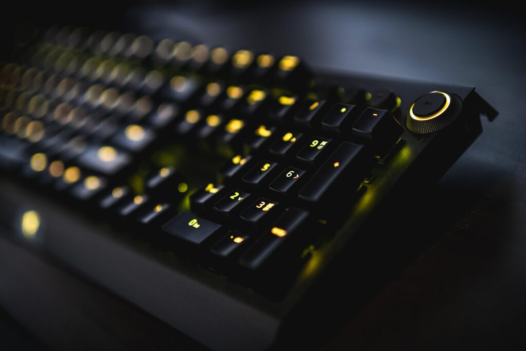 Blurred yellow RGB gaming keyboard on a black background featured in honest gaming gear reviews