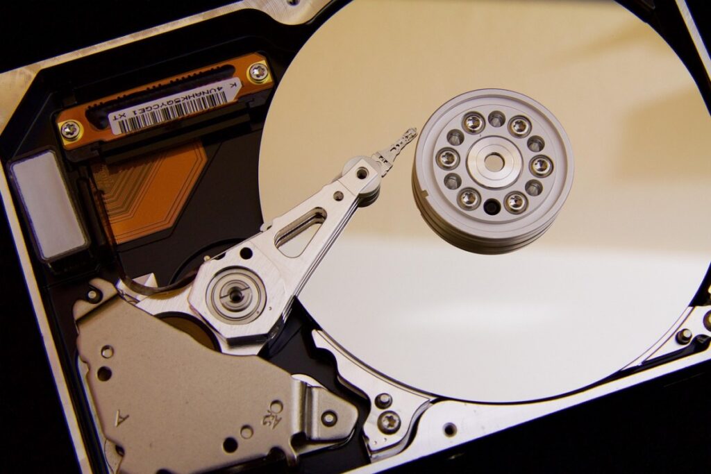 Opened hard drive showing spinning platters and read write arm