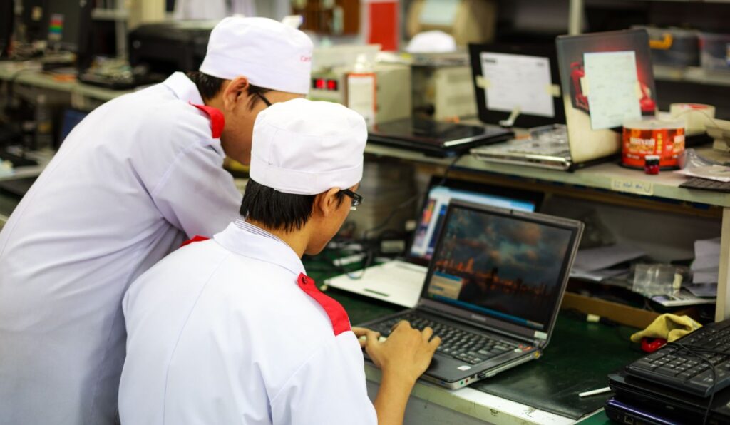 Computer technicians inspecting the internal components of a desktop gaming PC